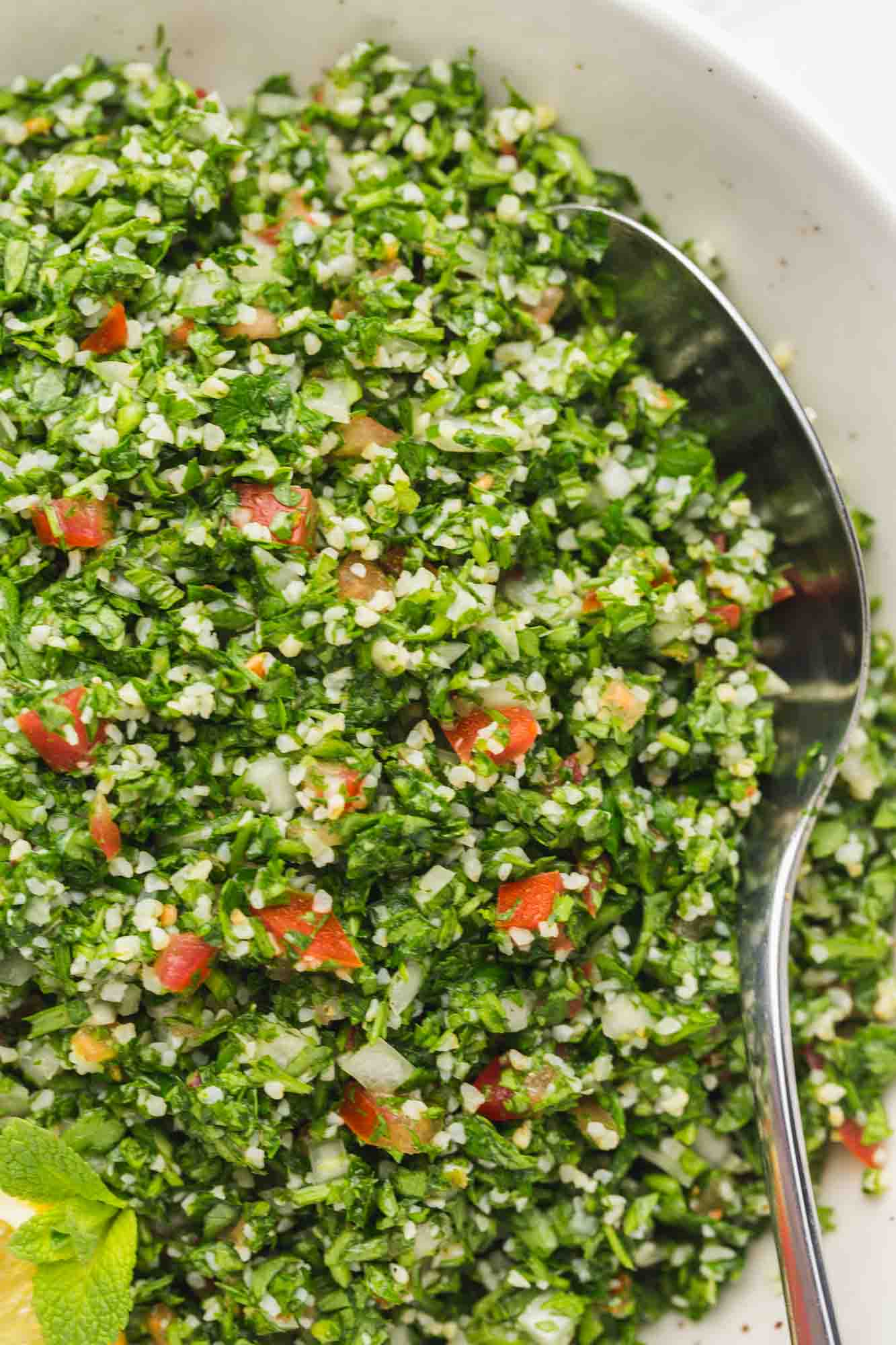 closeup view of a traditionally made lebanese tabbouleh salad with bulgar, herbs, and tomatoes