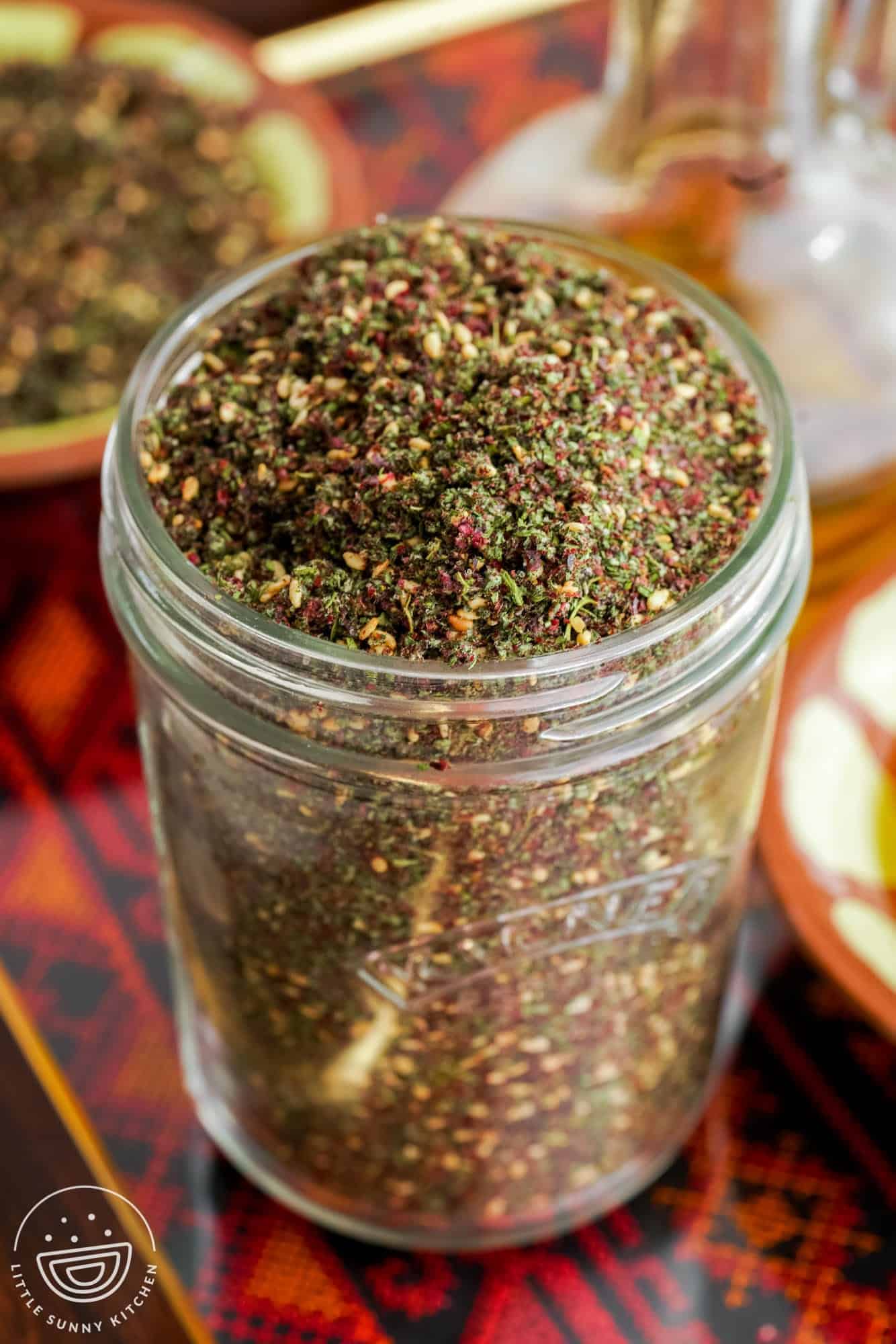 Zaatar spice in a glass Kilner jar, placed on a Palestinian embodied tray.