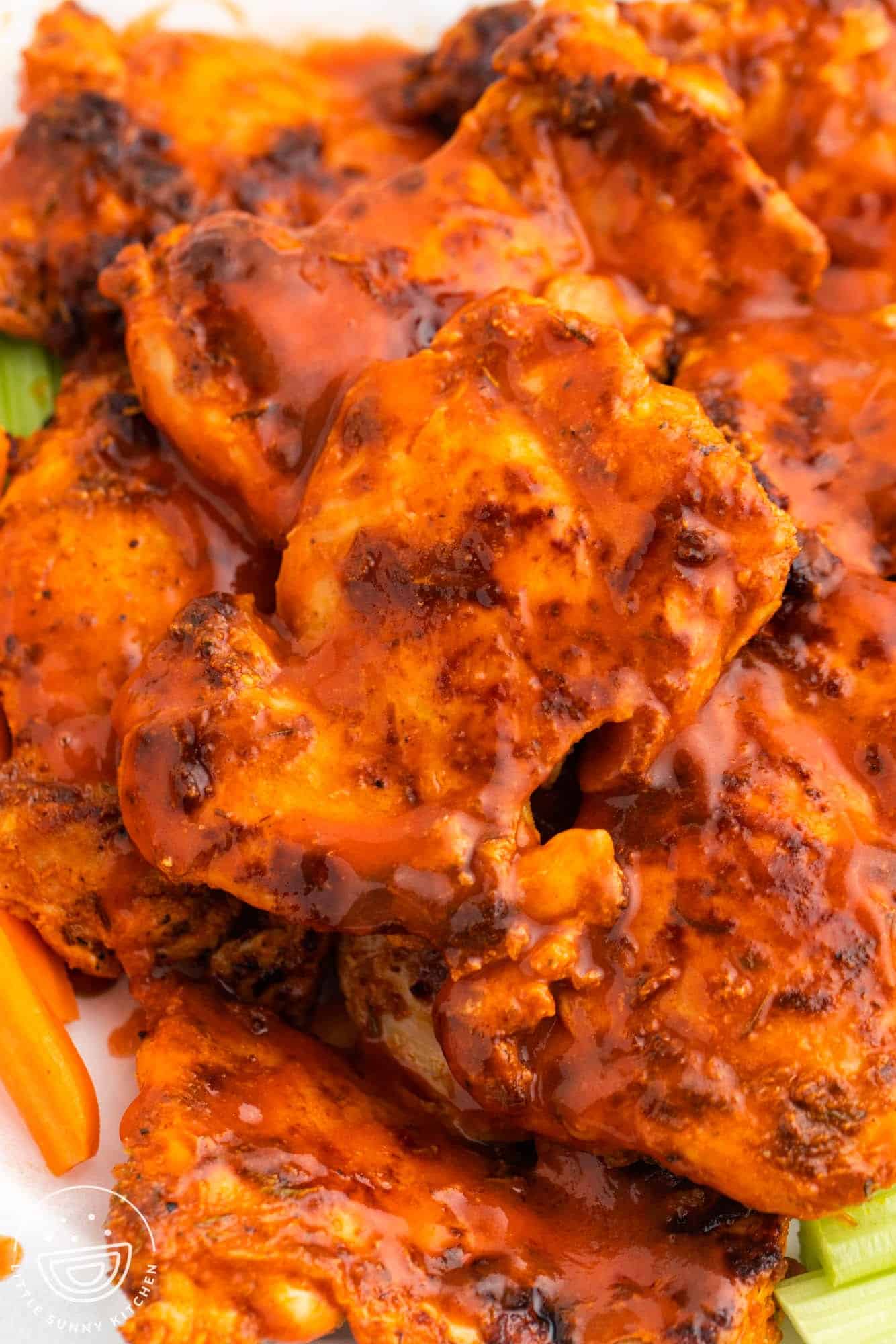 closeup of cooked boneless chicken thighs with buffalo sauce.