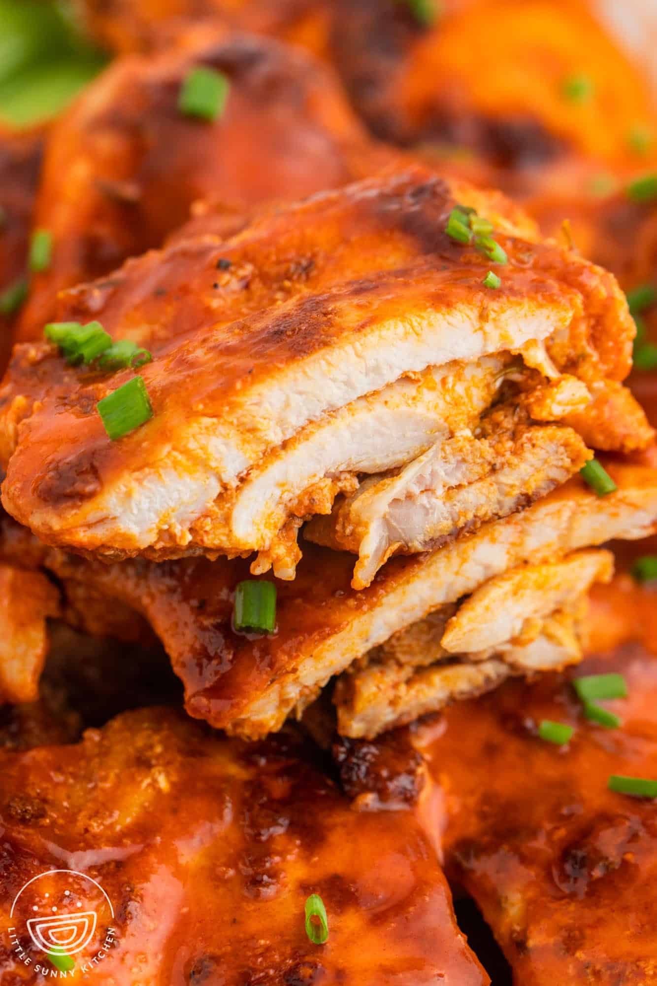 Buffalo chicken thighs, cut in half to show interior texture.