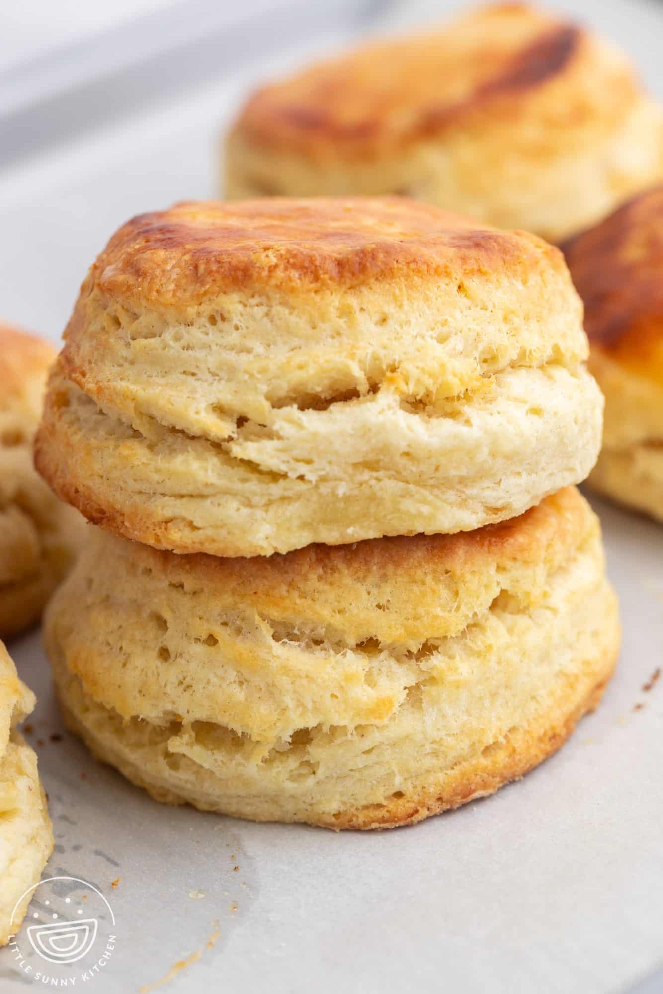two buttermilk biscuits stacked on top of each other.