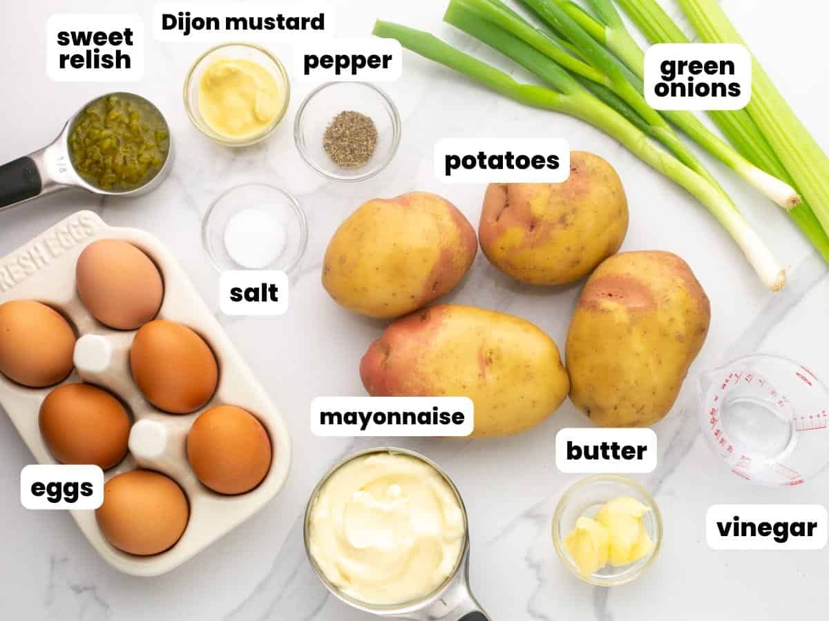 The ingredients needed to make deviled egg potato salad on a counter, labeled with text overlay