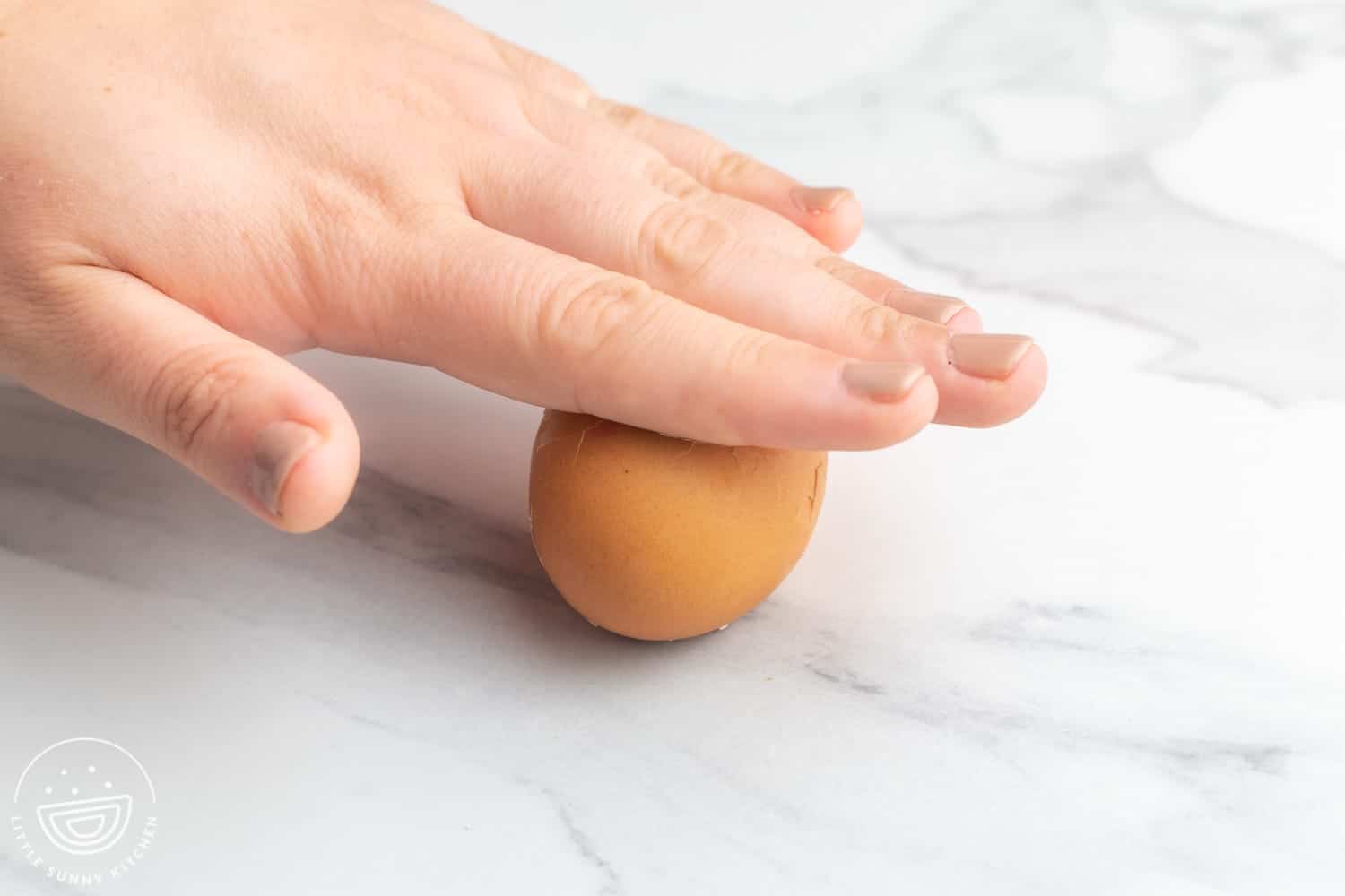 Rolling a hard boiled egg to peel it