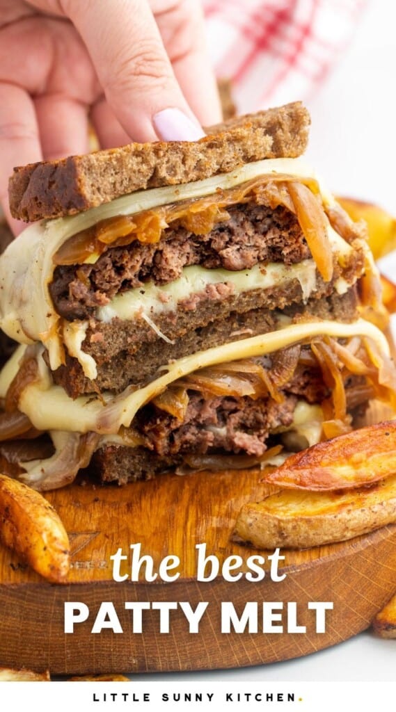 a patty melt, cut in half and stacked to show the inside. french fries are next to it on a wooden board. Text overlay says "the best patty melt"