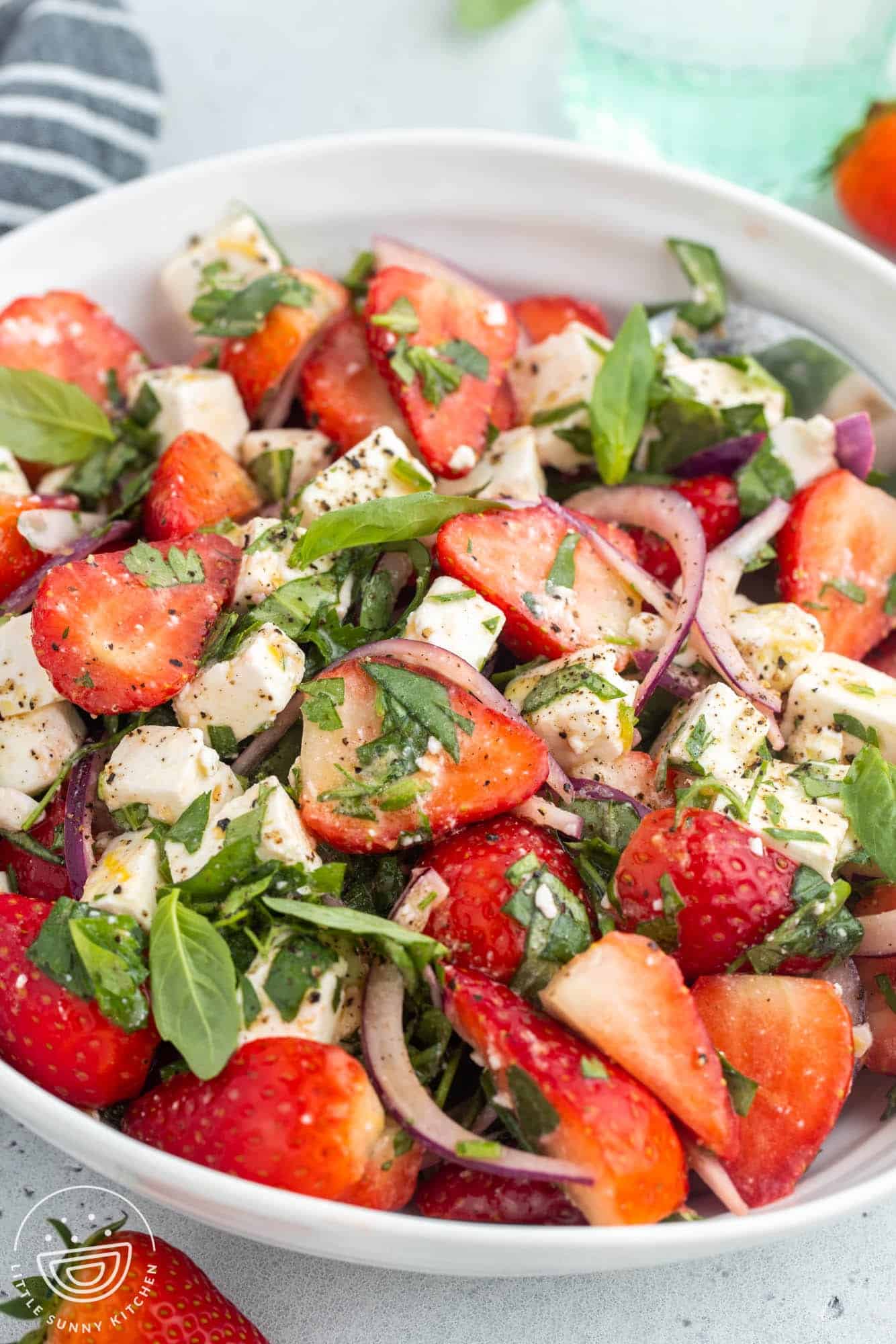 Angle shot of strawberry feta salad with fresh basil