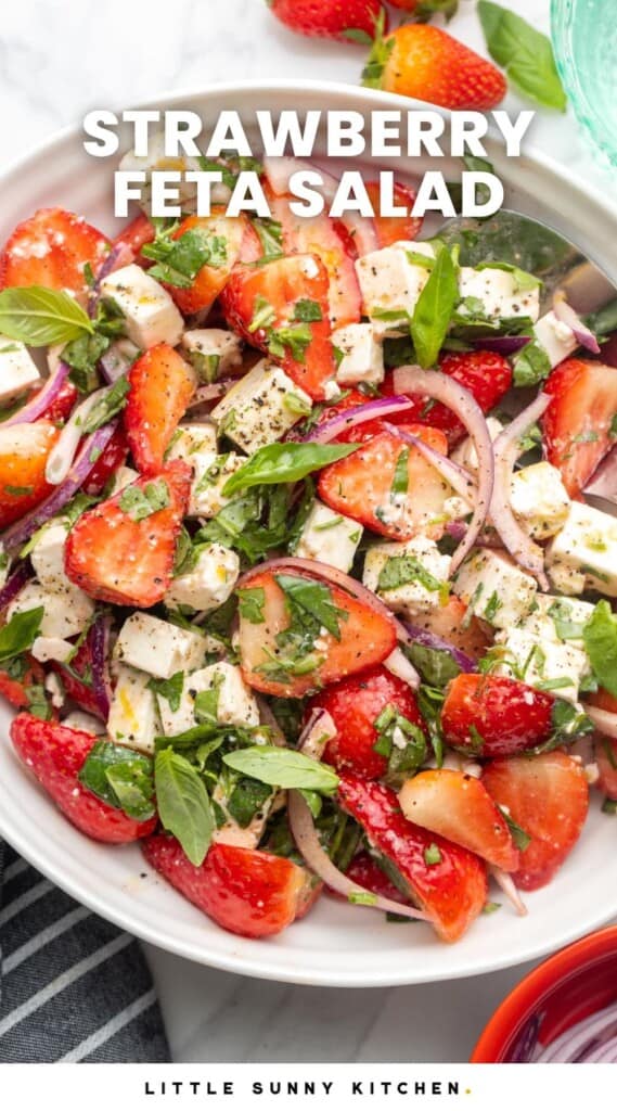 Overhead shot of strawberry feta salad in a white bowl. And overlay text that says "strawberry feta salad"