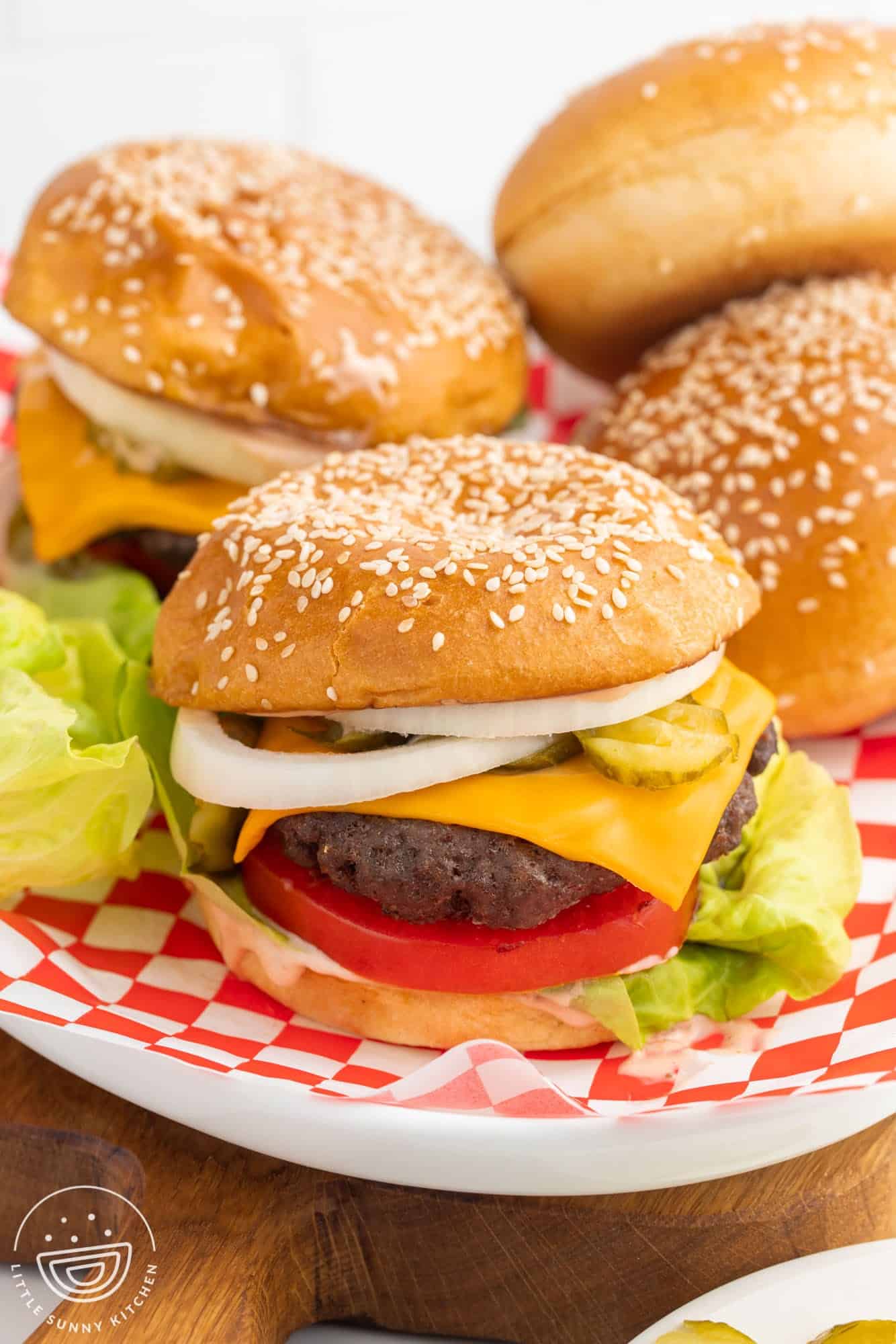 Hamburger made with beef patty, cheese, onion, tomato, lettuce, and a brioche bun.