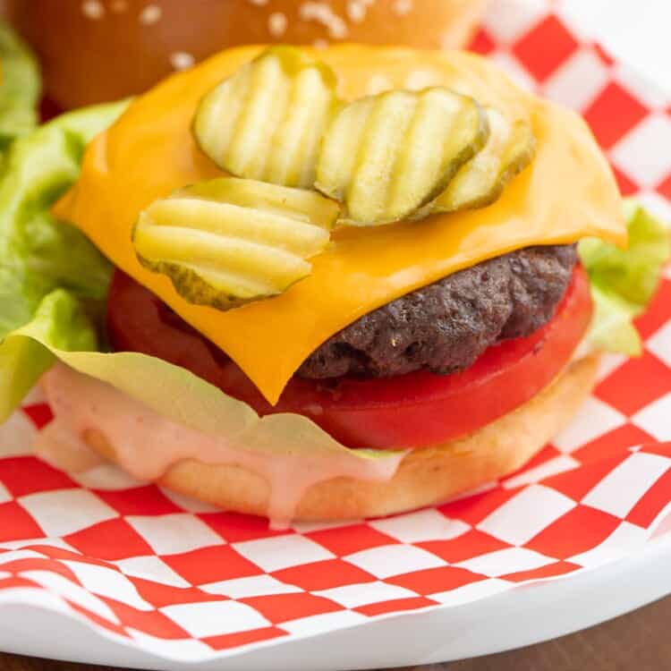 Hamburger made with beef patty, cheese, onion, tomato, lettuce, and pickle chips.