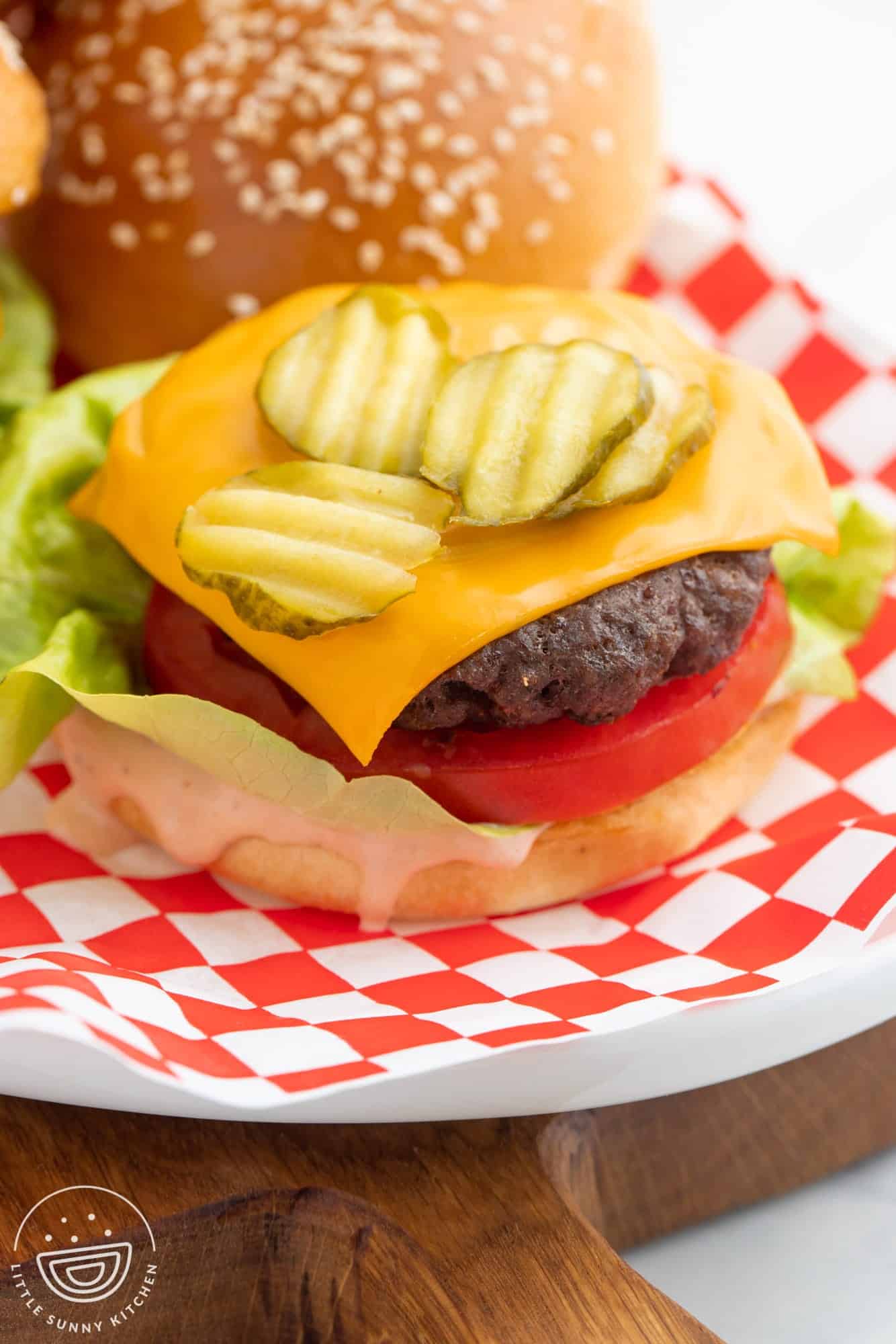 Hamburger made with beef patty, cheese, onion, tomato, lettuce, and pickle chips.