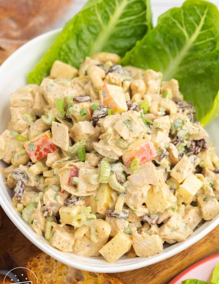 romaine leaves in a bowl filled with curry chicken salad.