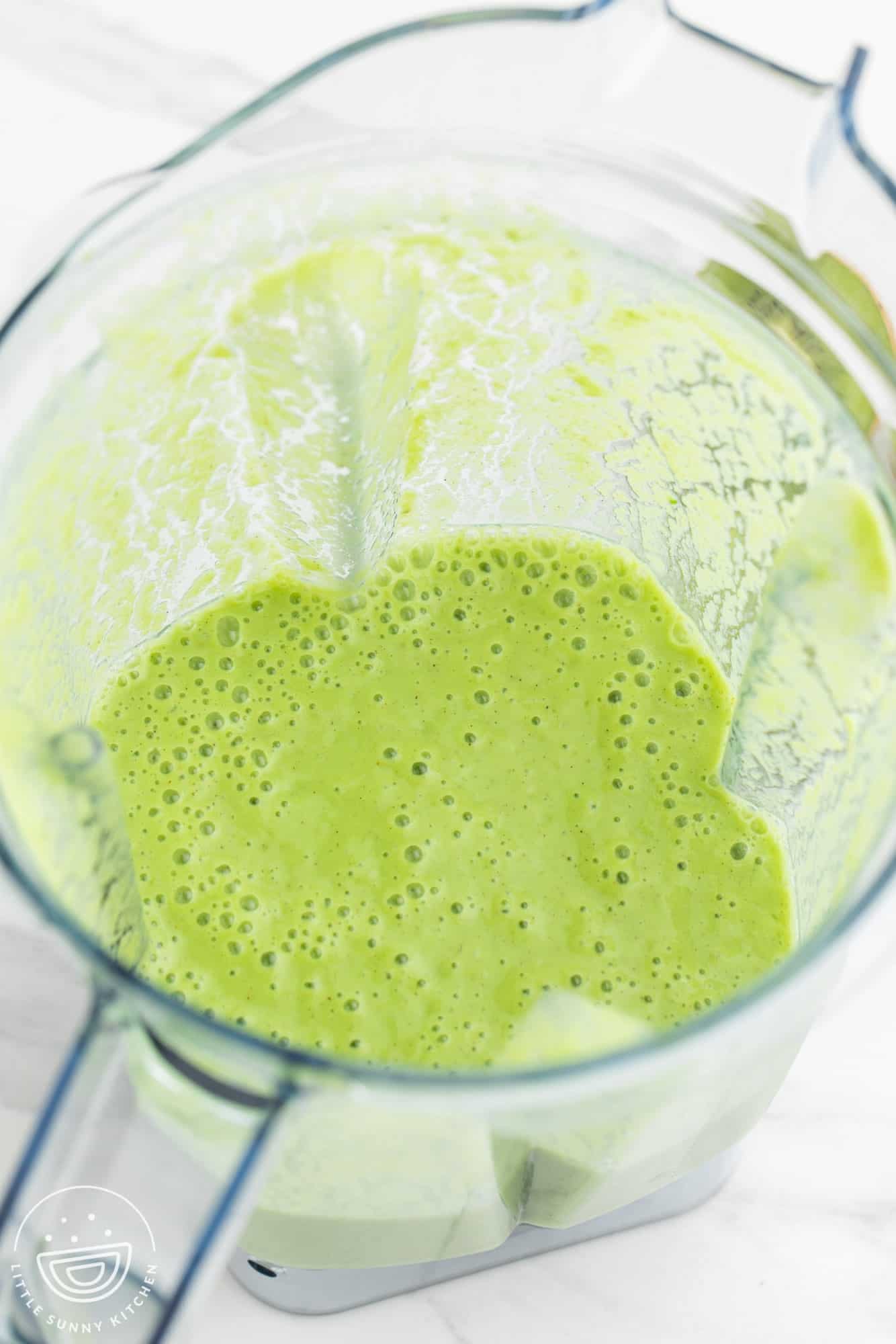 Blended green kiwi smoothie in a blender jug