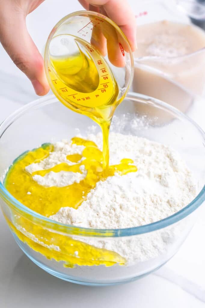 Adding olive oil to flour mixture to make manakish dough