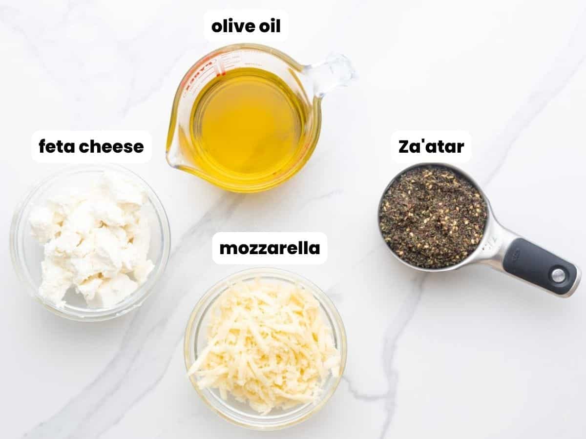 Ingredients needed for the manakish fillings including olive oil, za'atar, feta cheese, and shredded mozzarella.