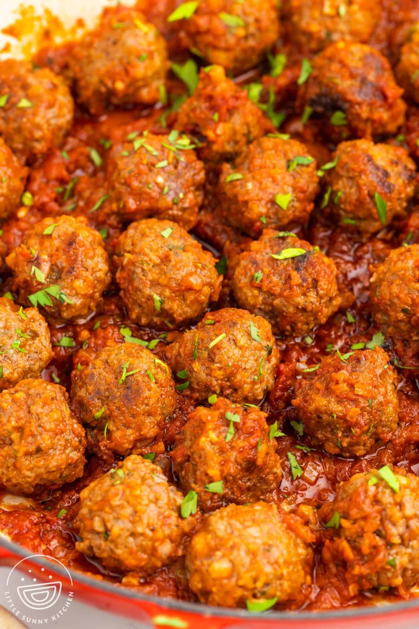 beef meatballs in a pan with tomato sauce