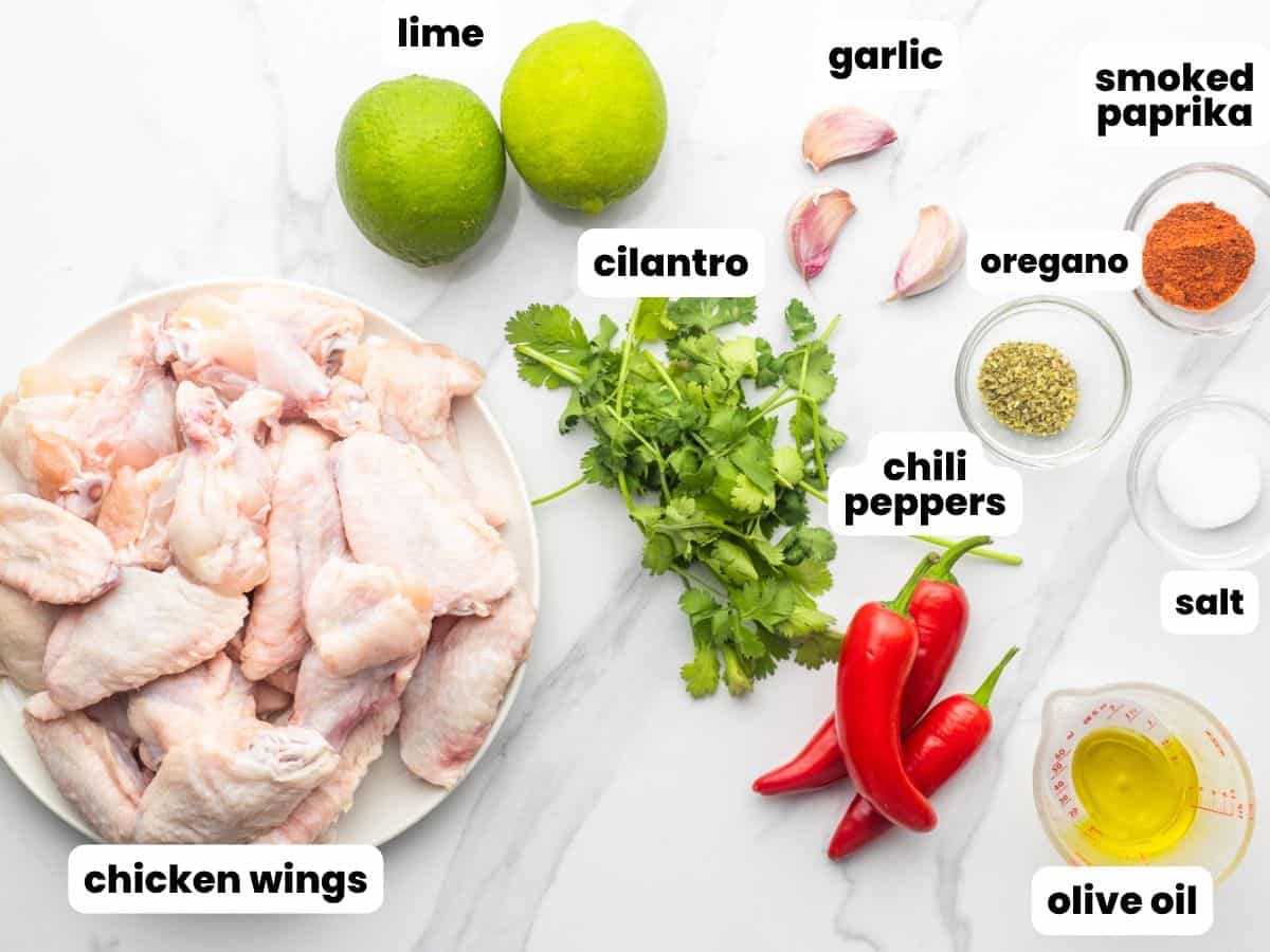 the ingredients for peri peri wings, including lime, chili peppers, garlic, and cilantro.