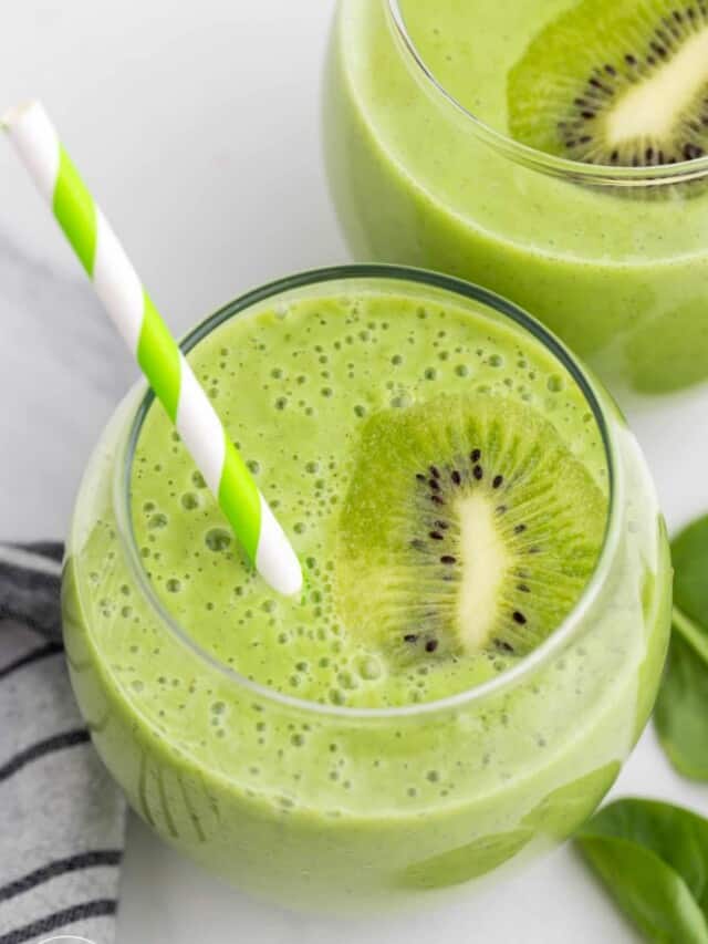 Close up shot of glasses filled with kiwi smoothie, and green straw.