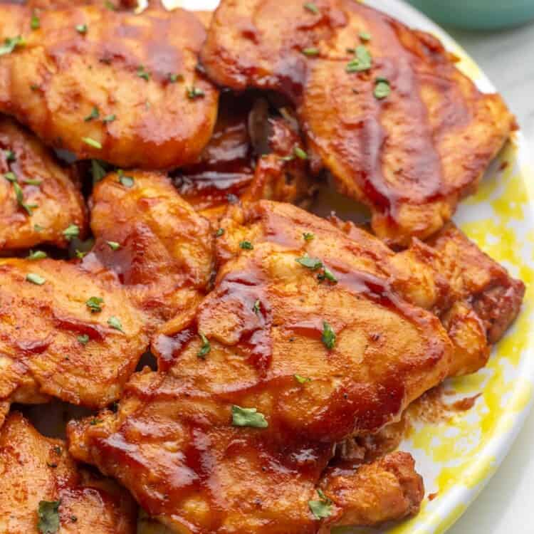 A platter of bbq sauced baked chicken thighs.