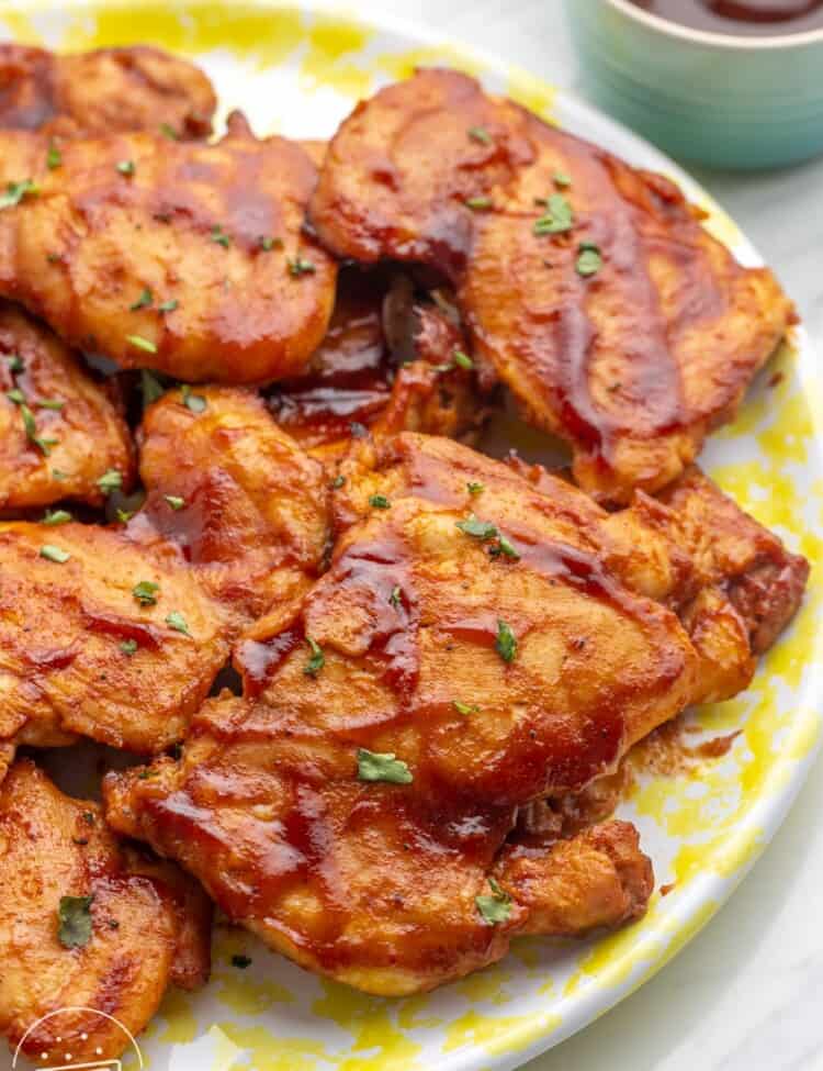 A platter of bbq sauced baked chicken thighs.