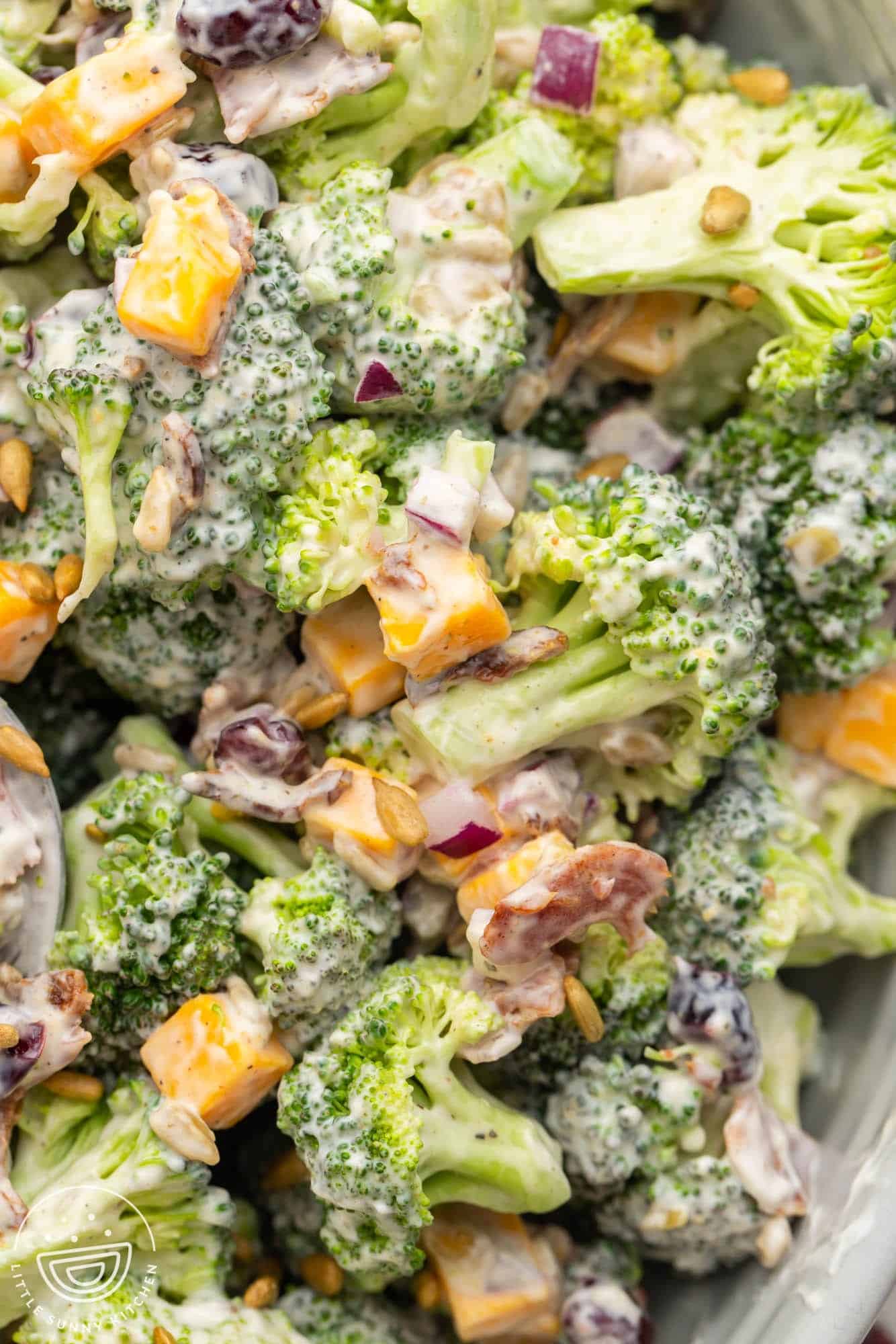 A closeup view of a bowl of creamy broccoli salad.