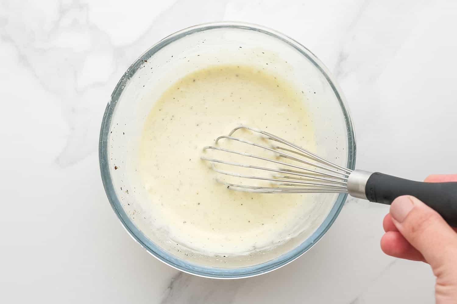 creamy dressing for broccoli slaw, whisked together in a small glass bowl.