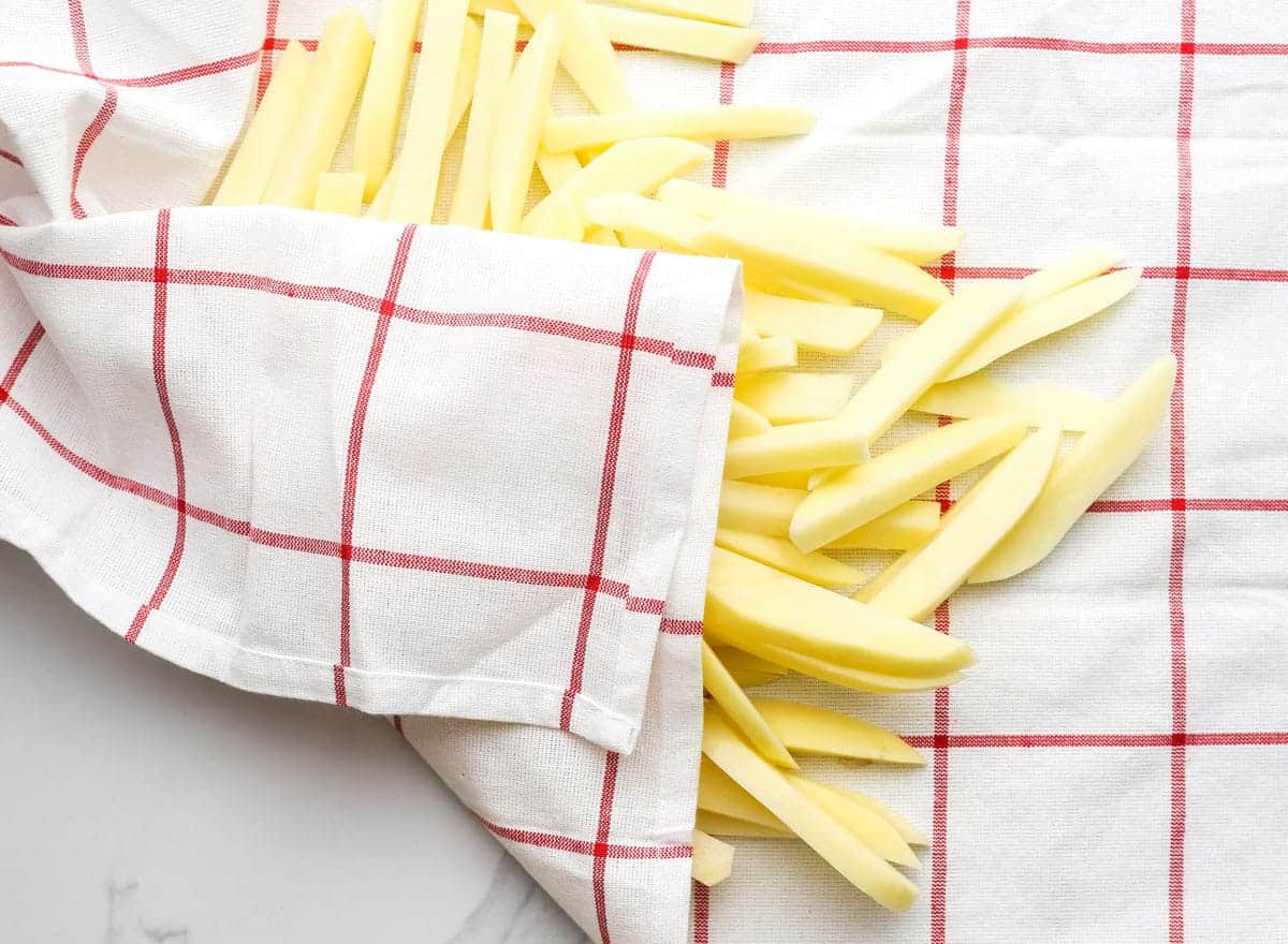 Sliced potatoes drying on a kitchen towel