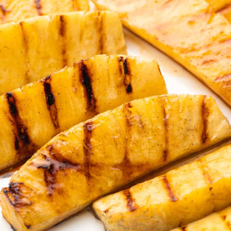 Grilled pineapple spears served on a large white platter