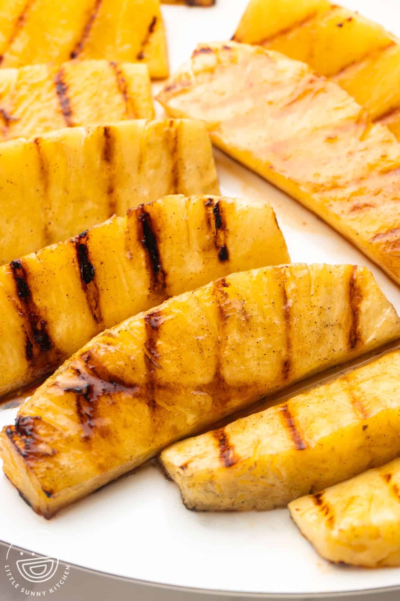 Grilled pineapple spears served on a large white platter