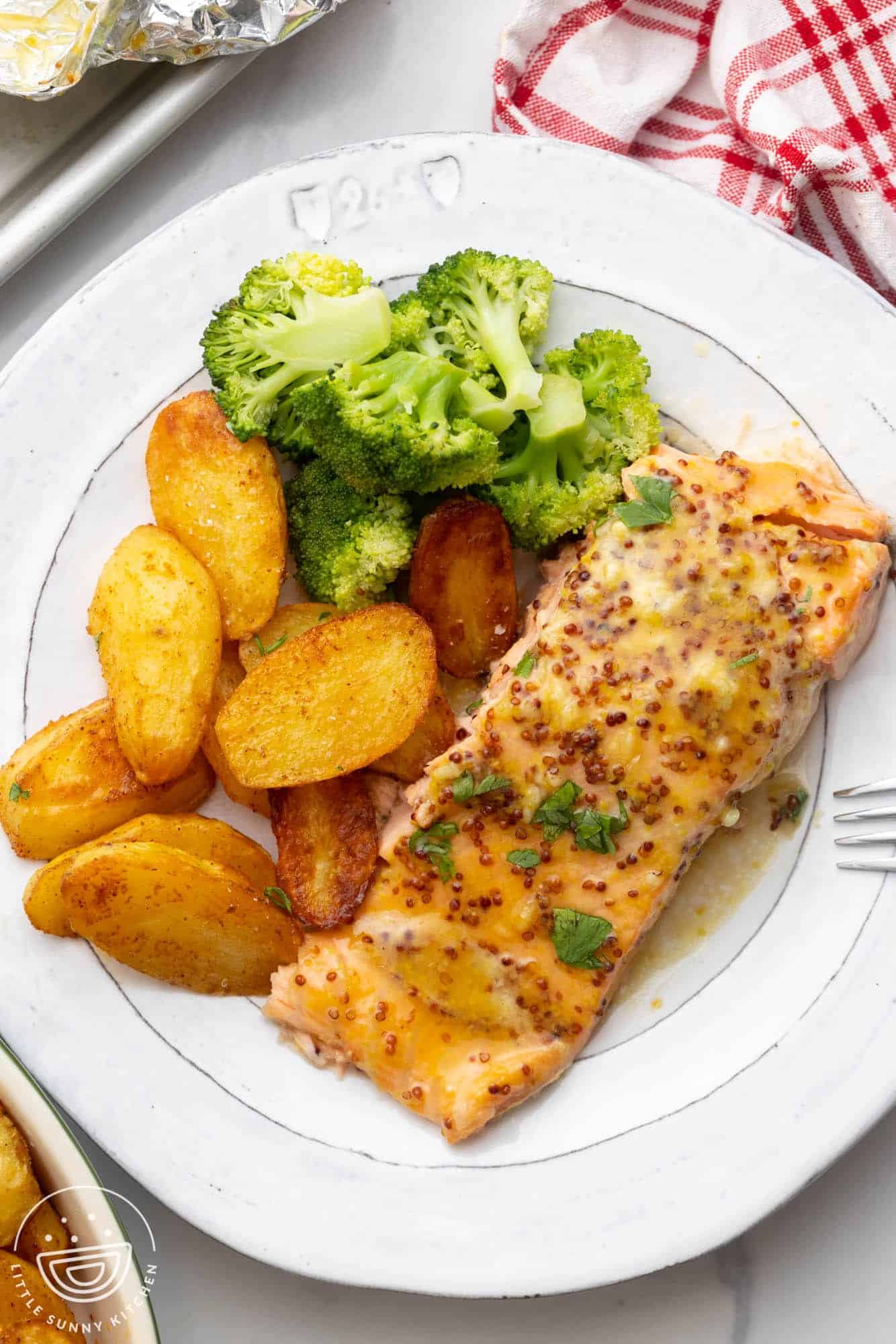 a dinner plate of honey mustard salmon, fingerling potatoes, and broccoli