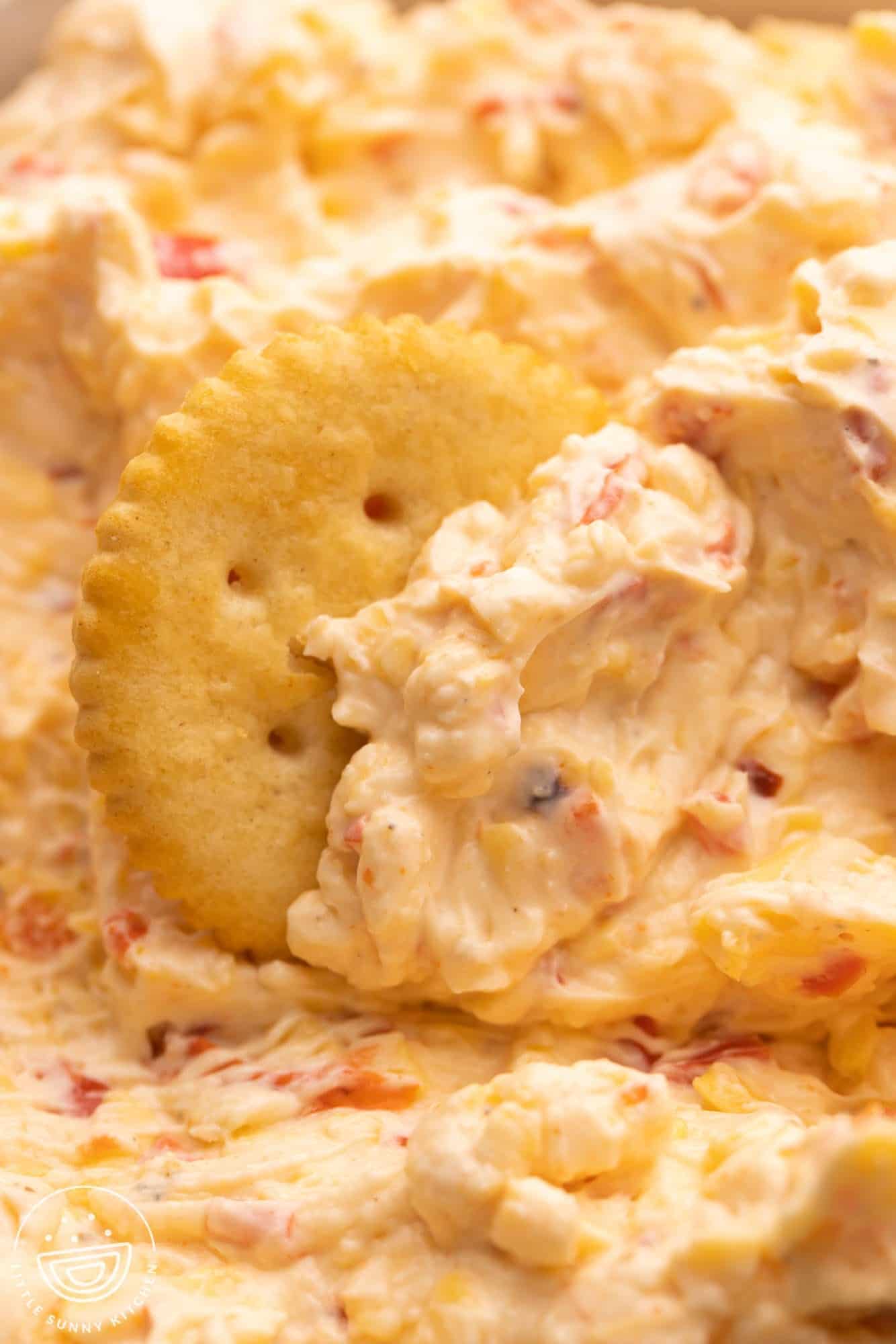closeup of a ritz cracker in a bowl of pimento cheese.