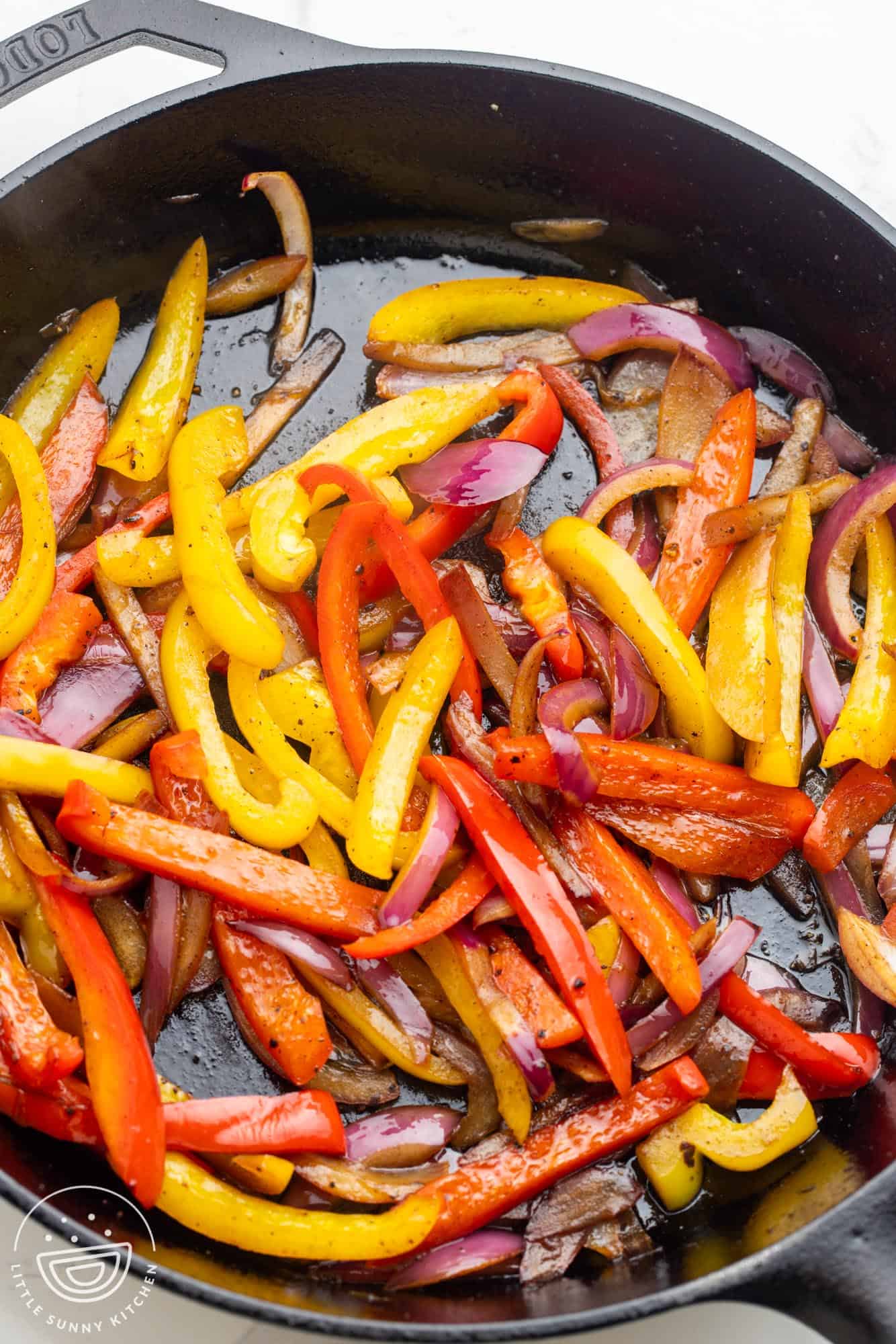 red and yellow bell peppers and onions, sauteed in a cast iron frying pan