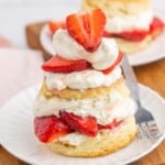 Strawberry shortcake on a small white plate and a fork on the side
