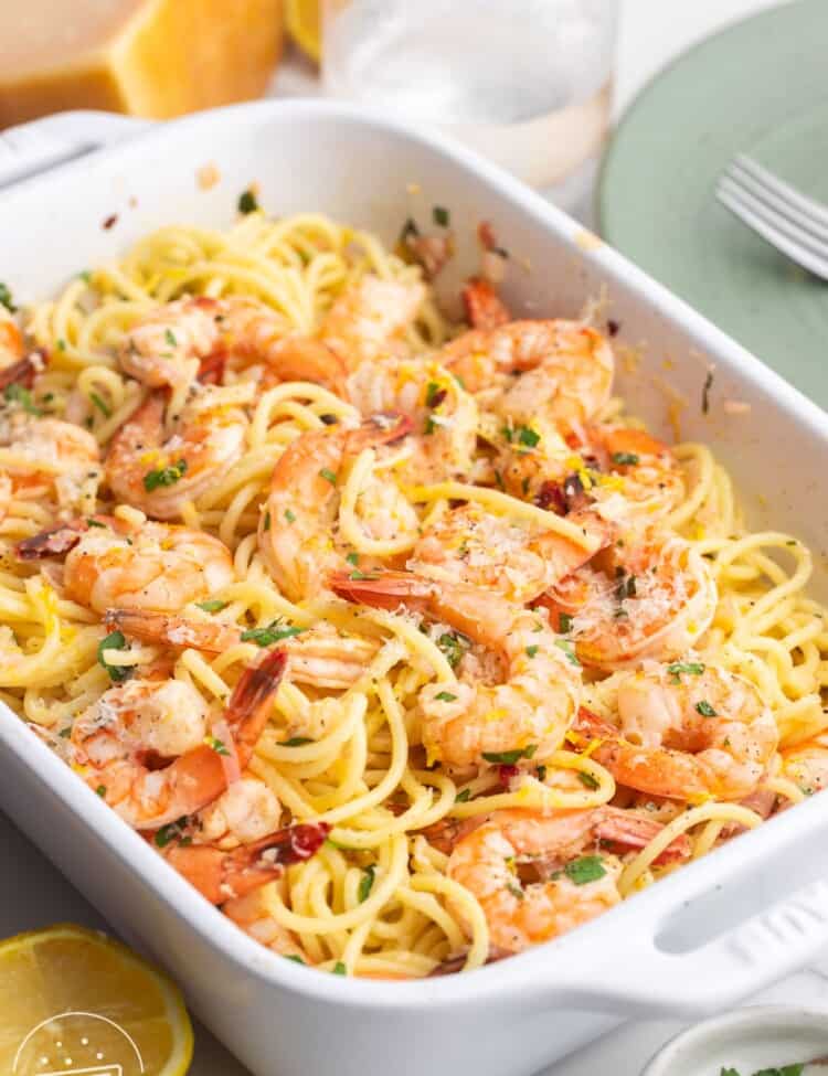 a rectangle baking dish filled with baked shrimp scampi with spaghetti noodles
