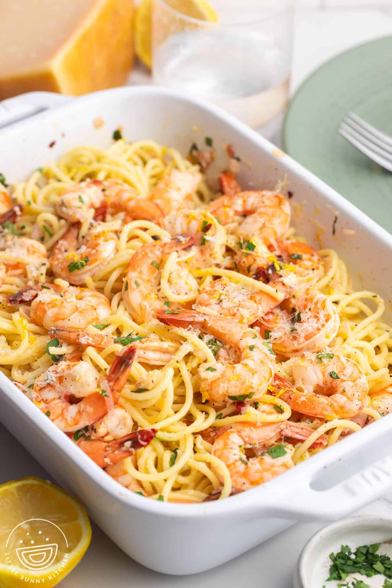 a rectangle baking dish filled with baked shrimp scampi with spaghetti noodles