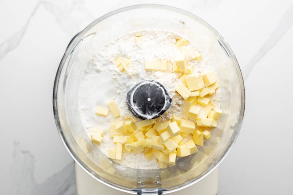 Cold butter and flour in the jug of a food processor