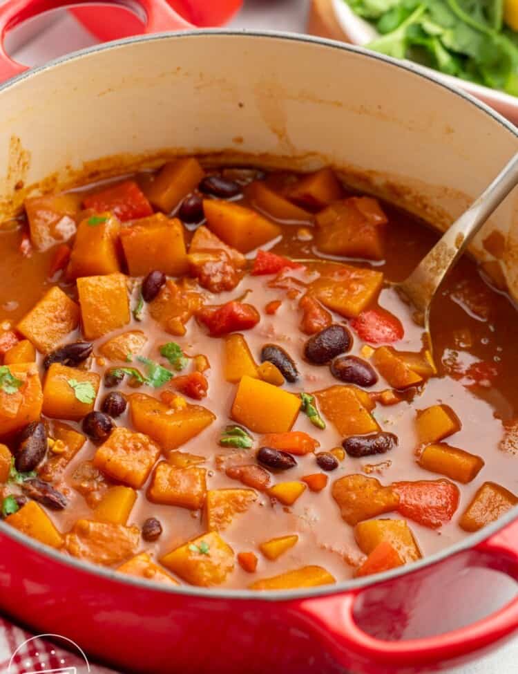 a red dutch oven filled with butternut squash chili