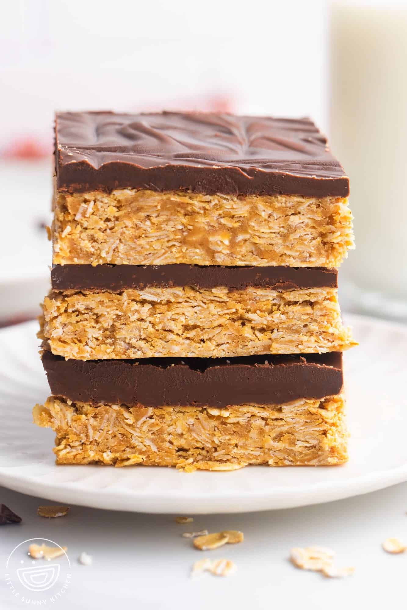 three chocolate peanut butter oatmeal bars stacked on a plate.