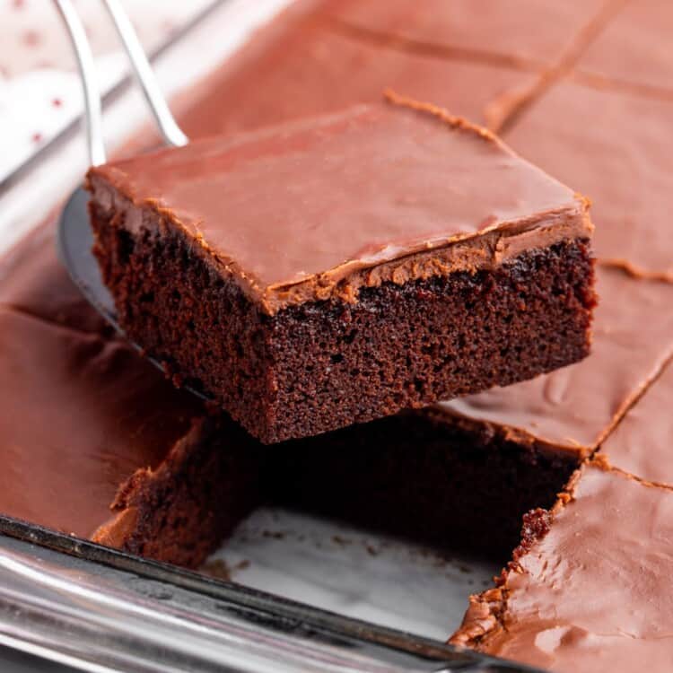 a spatula lifting a square slice of homemade coca cola cake out of a pan