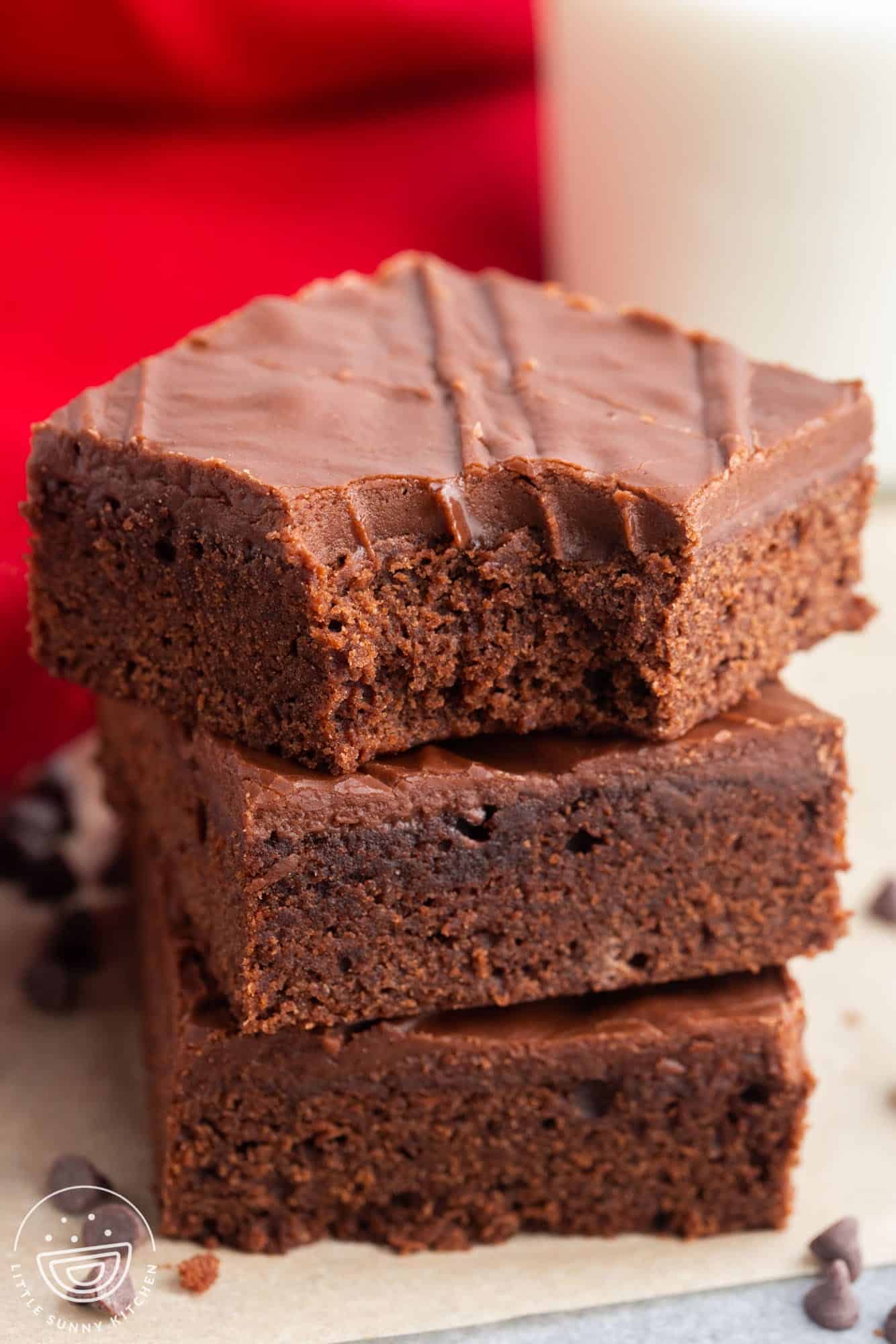 a stack of three lunch lady brownies with chocolate frosting.
