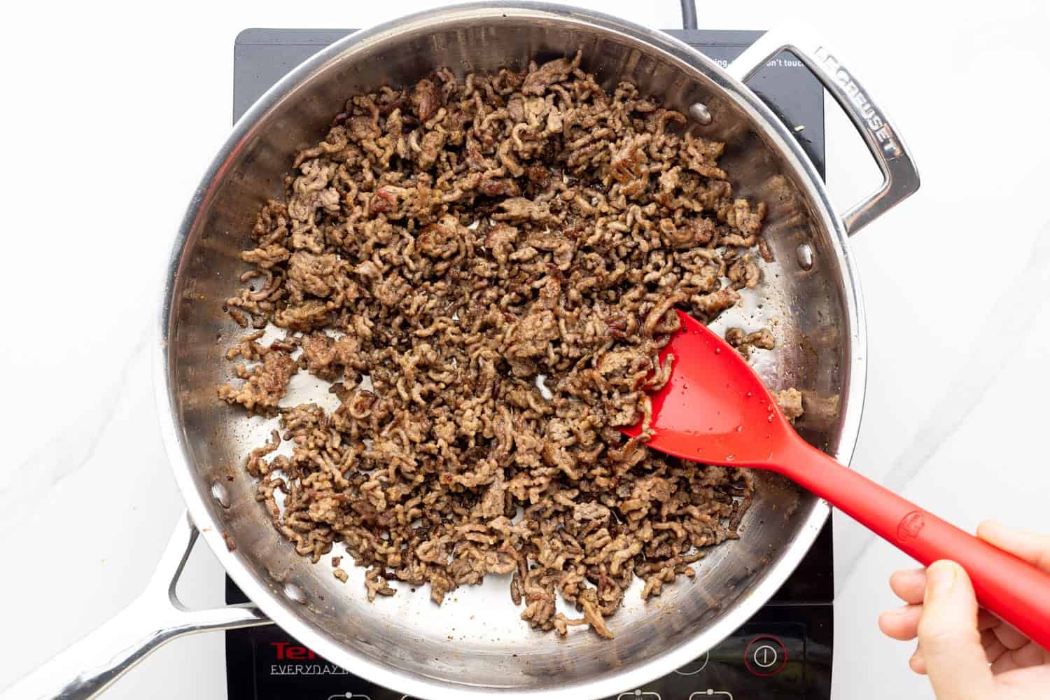 ground beef cooking in a skillet.