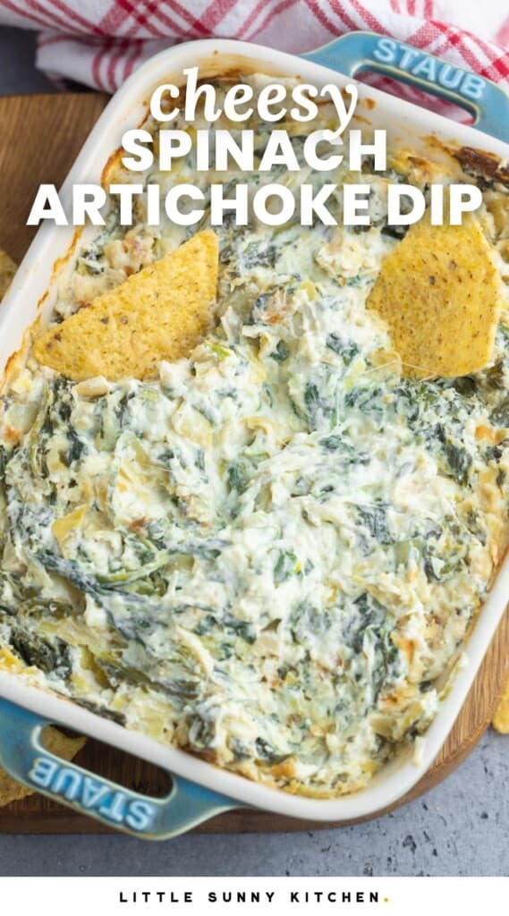 Overhead shot of baked spinach and artichoke dip in a rectangular small dish, and 2 tortilla chips.