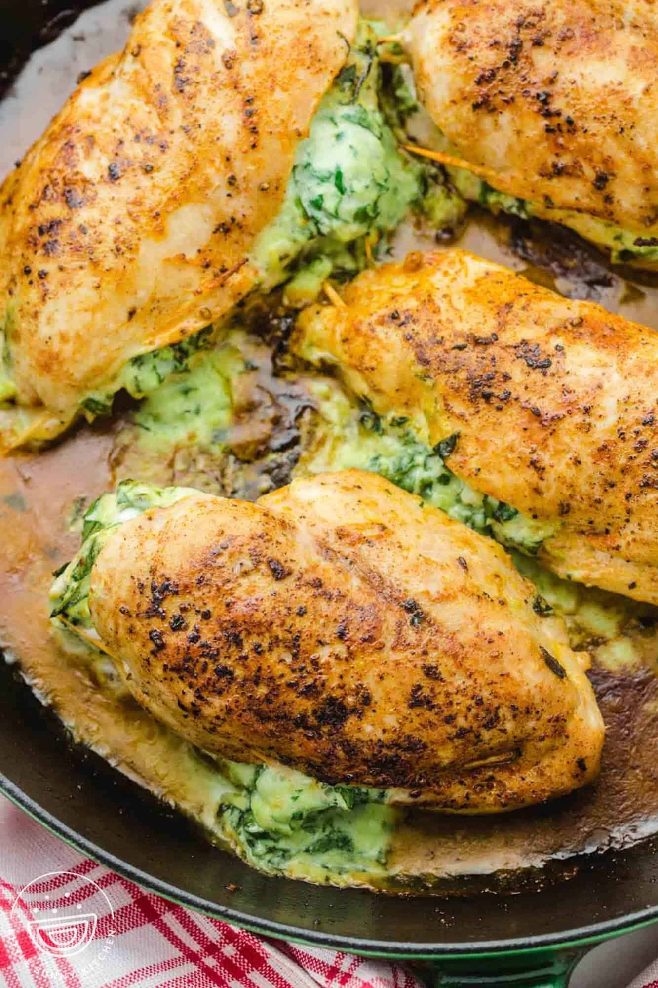 Spinach stuffed chicken breasts in a cast iron skillet