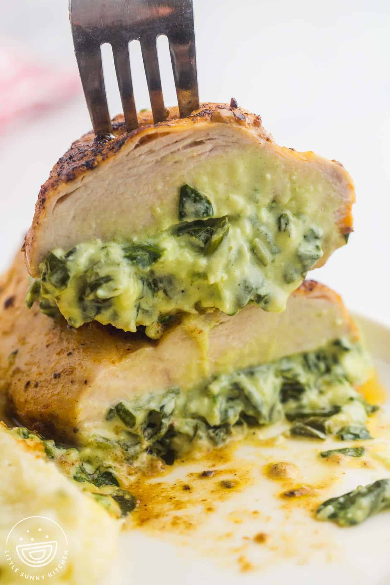 Sliced spinach and cheese stuffed chicken breasts showing the melted filling inside the chicken breast