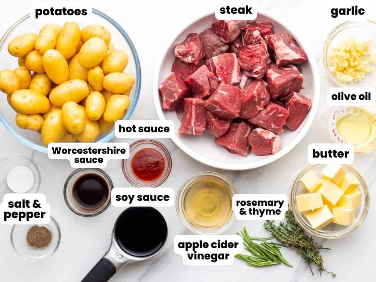 The ingredients needed to make steak bites and potatoes in a skillet.