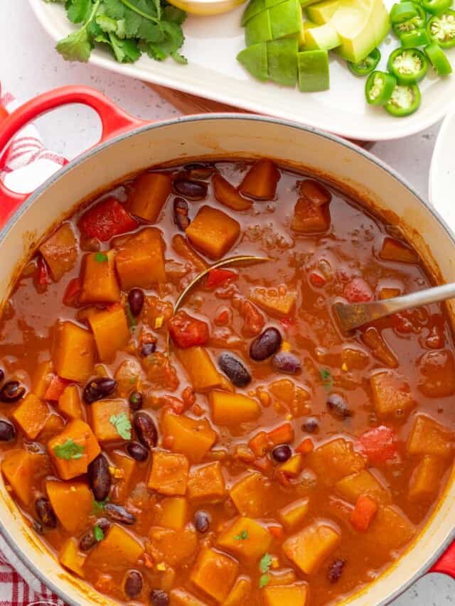 a pot of vegetarian chili with squash and beans, viewed from overhead.