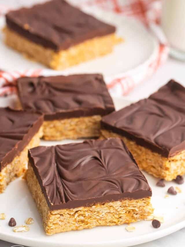 a plate holding four square oatmeal bars with chocolate topping.