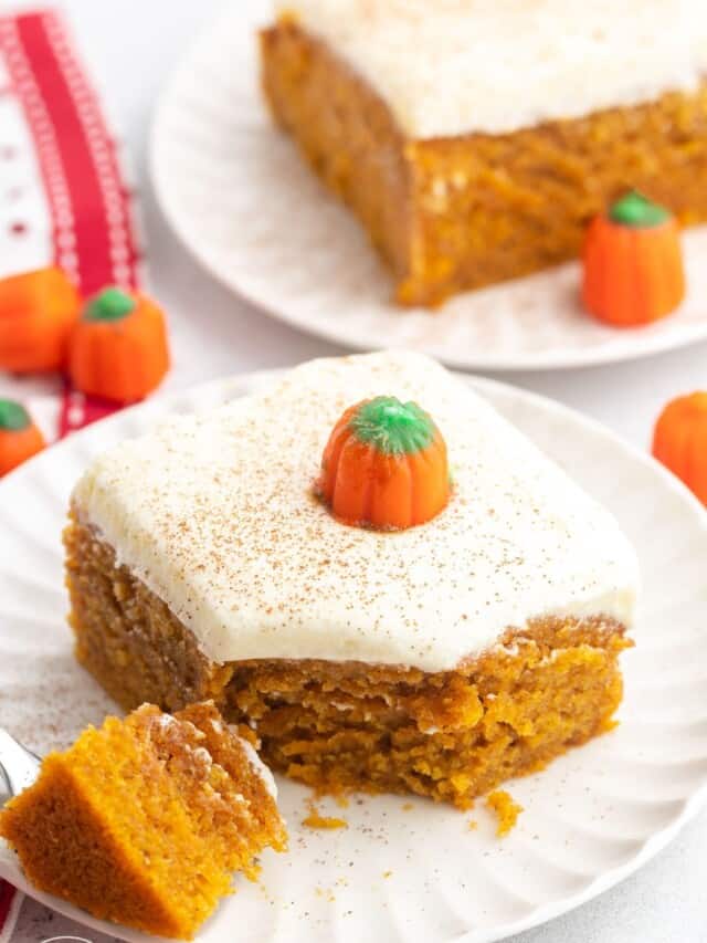a square piece of pumpkin cake with frosting on a dessert plate.