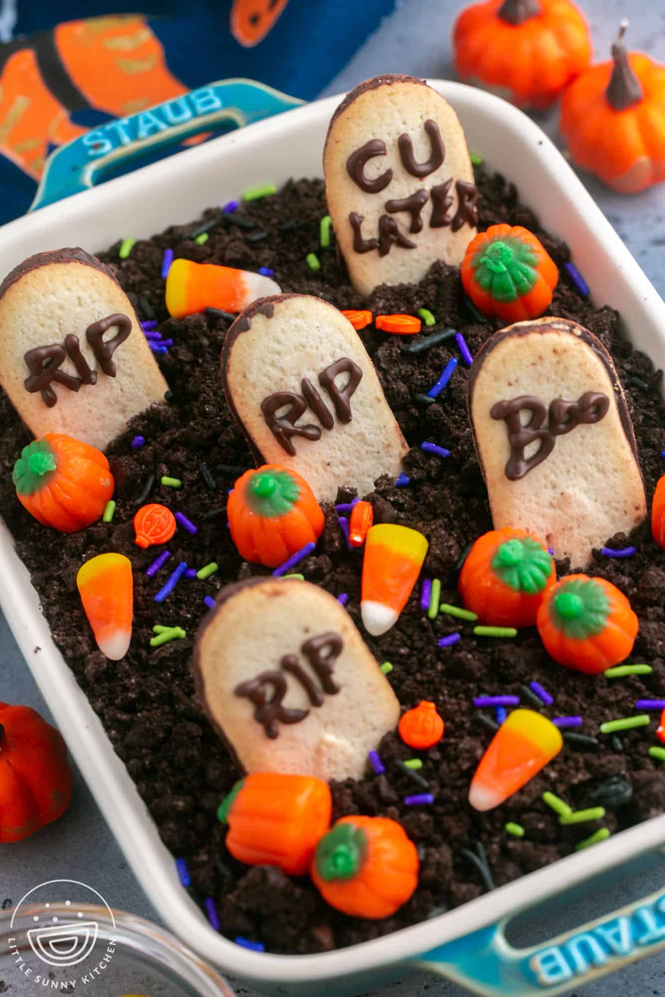Angle shot of Graveyard Chocolate Cheesecake Dip in a Staub dish, decorated with halloween candy and sprinkles