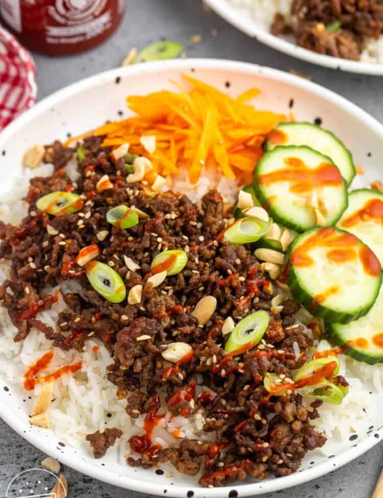 a korean rice bowl with ground beef and veggies.
