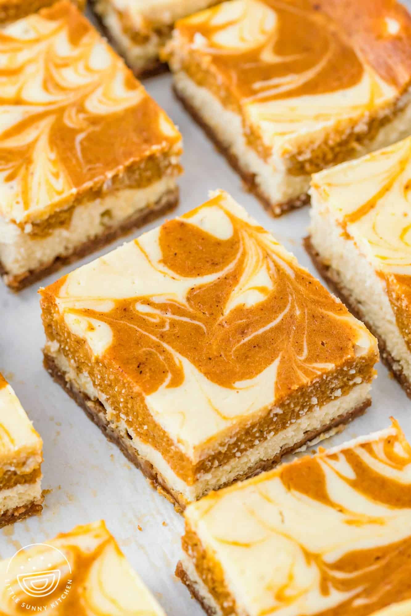 pumpkin cheesecake squares on parchment paper.