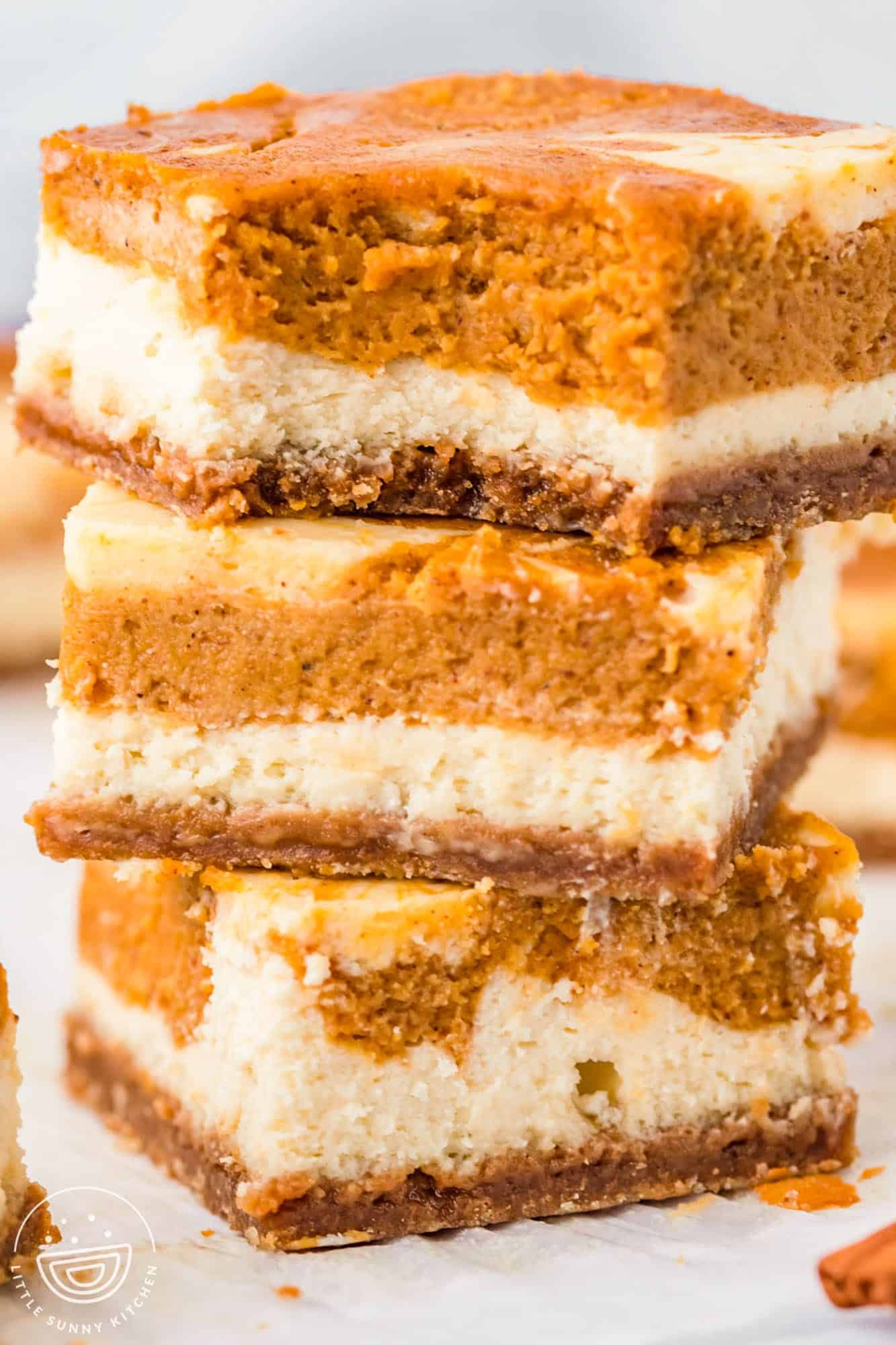 closeup shot of three layered pumpkin cheesecake squares.